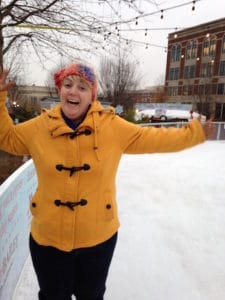 woman in yellow coat skating on an open-air ice rink