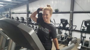 Crystal Pace on a Treadmill in a Gym with Weights