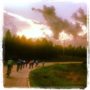 cyclists riding at sunset