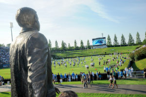 statue in the foreground with carolina panthers on the field in the background