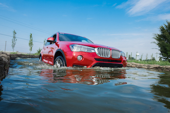red bmw driving through water